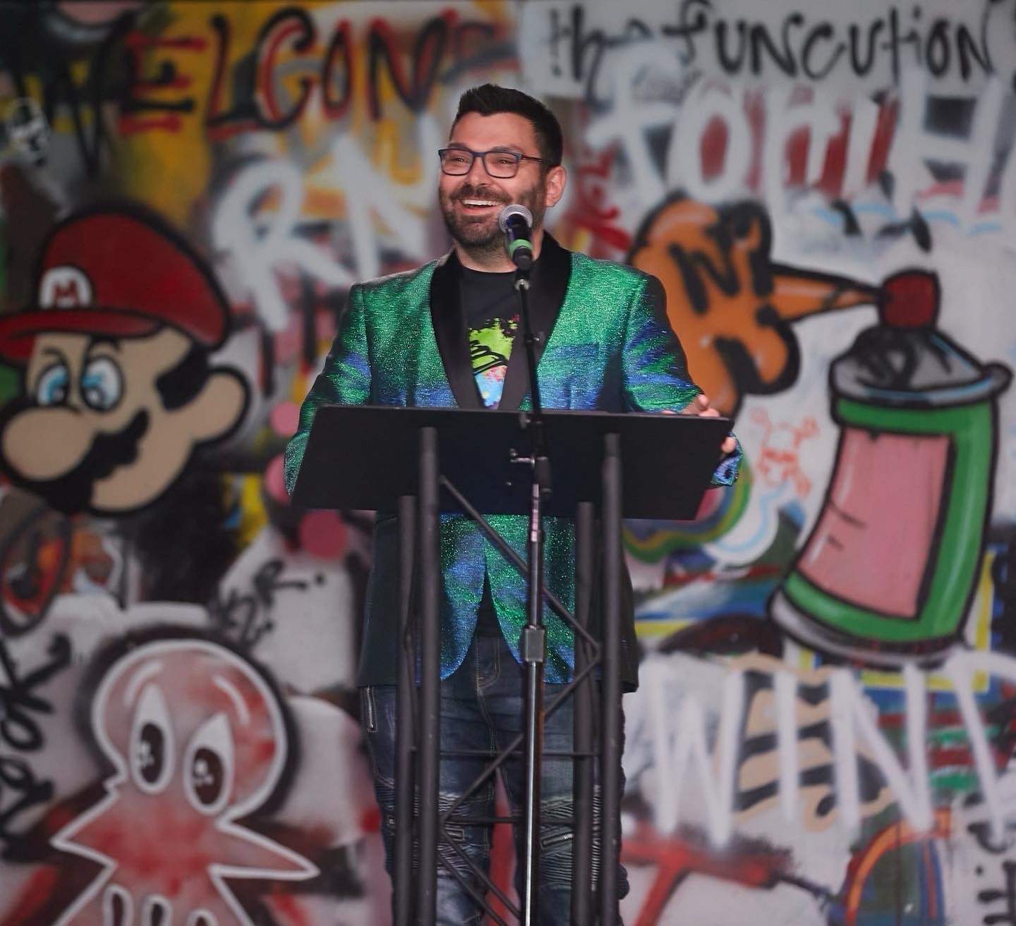 Clif Mathews at a gala event in a sparkly jacket at the podium